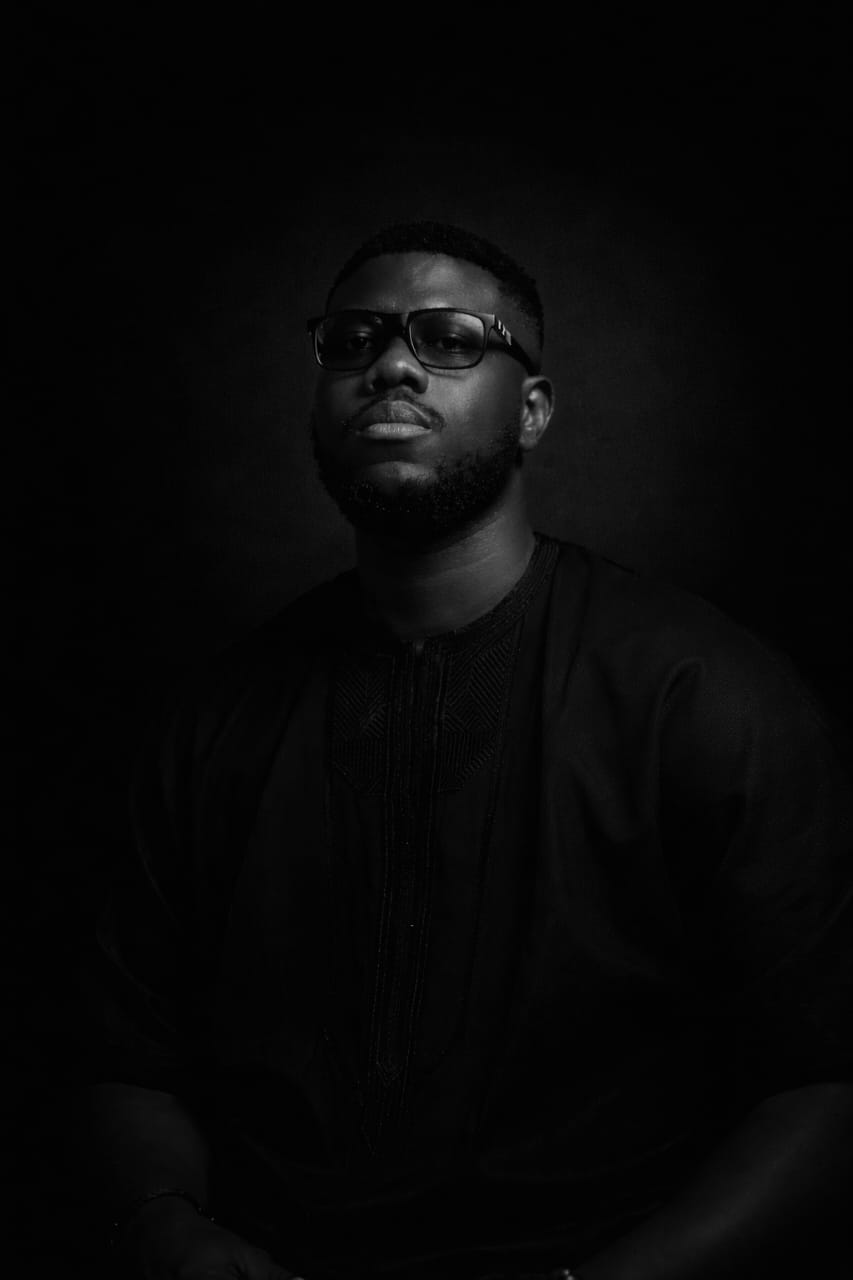 Black and white portrait of Bolade Akerele wearing glasses